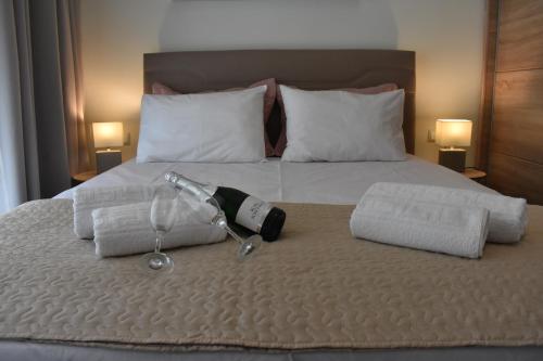 a bottle of wine on a bed with towels at Chrysafenia & Leandros Downtown in Kavála