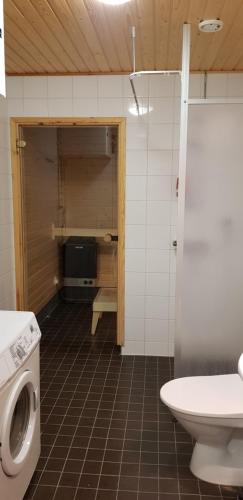 a bathroom with a washing machine and a toilet at Apartment in City - Antinkatu in Pori