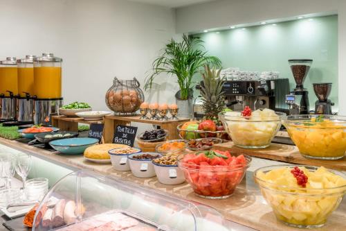 a buffet with many different types of food in bowls at Aparthotel Mariano Cubi Barcelona in Barcelona