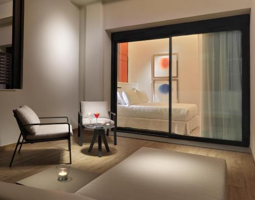 a room with a bedroom with a bed and a mirror at H10 Cubik 4* Sup in Barcelona