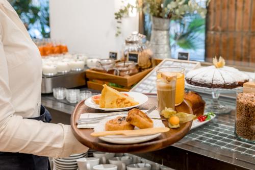 a person holding a tray of food and drinks at Aparthotel Mariano Cubi Barcelona in Barcelona