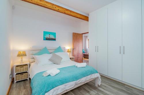 a bedroom with a bed with two towels on it at Mountain View Cabana in Kommetjie