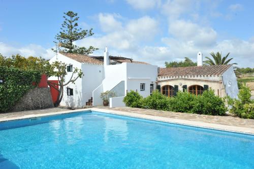 una villa con piscina di fronte a una casa di Menorca Agroturismo Llimpet ad Alaior