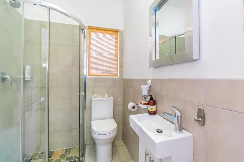 a bathroom with a toilet and a sink and a shower at Mountain View Cabana in Kommetjie