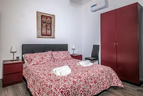 a bedroom with a red bed with two white towels on it at B&B Amalfi's Luxury Rooms in Salerno