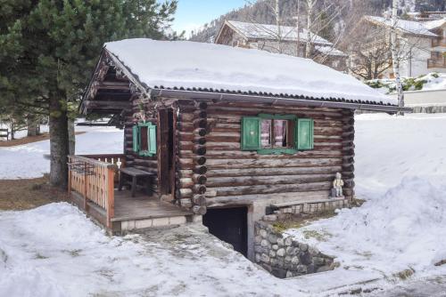 a log cabin with a snow covered roof at Ciasa Christina - Attic in Moena