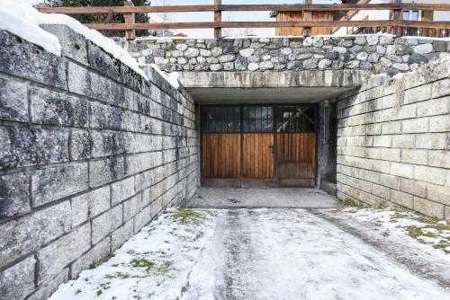 a brick tunnel with a wooden door with snow on the ground at Ciasa Christina - Attic in Moena