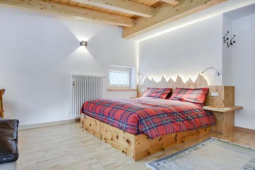 a bedroom with a wooden bed with red pillows at Ciasa Christina - Attic in Moena
