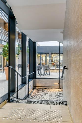 Un escalier mène à un bâtiment avec des portes en verre. dans l'établissement Les Patios de St-Pierre, à Palavas-les-Flots