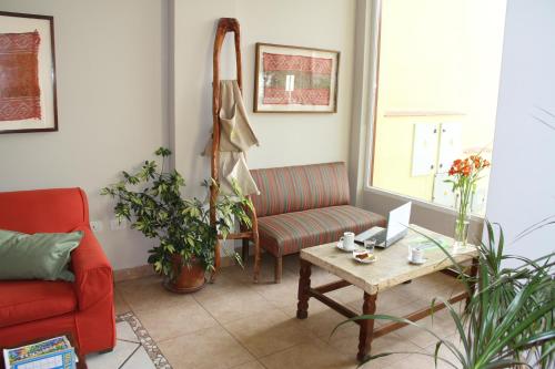 a living room with a red couch and a table at Altos De Balcarce Hotel in Salta