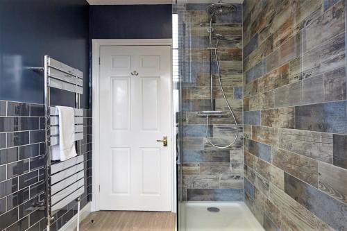 a bathroom with a shower and a bath tub at The Sunningdale - Your Apartment in Bristol