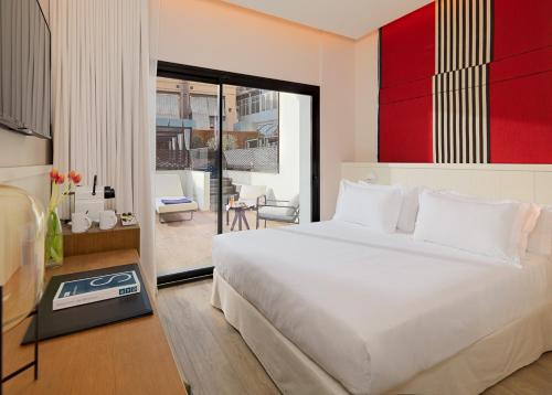 
a hotel room with a bed and a desk at H10 Cubik 4* Sup in Barcelona
