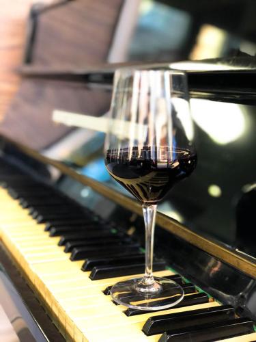 a glass of wine sitting on top of a piano at Boutique Hotel Nea in Brčko