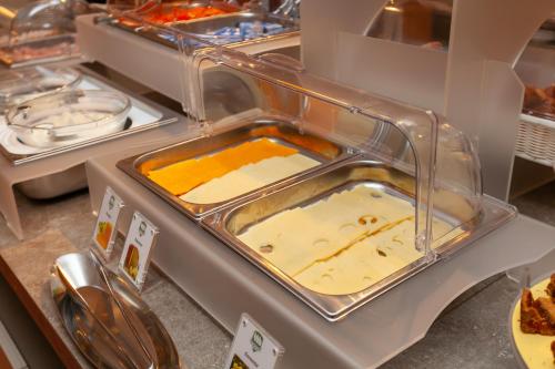 a buffet line with trays filled with food at Hotel Mirage Sure Hotel Collection by Best Western in Milan