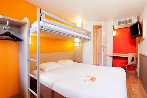 Premiere Classe Caen Est - Mondeville في مونديفيل: غرفة نوم مع سرير وسرير بطابقين
