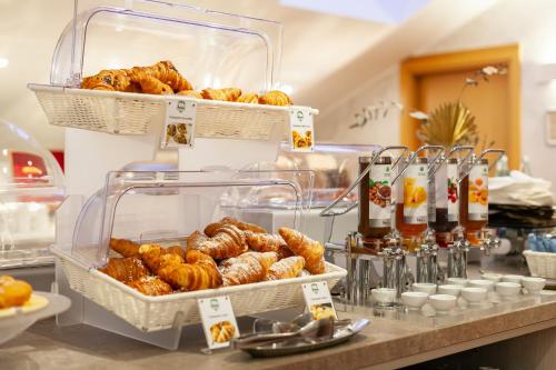 a buffet with pastries and croissants on a counter at Hotel Mirage Sure Hotel Collection by Best Western in Milan