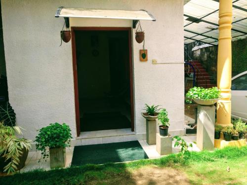 a front door of a house with potted plants at Villa Two Residence in Mount Lavinia