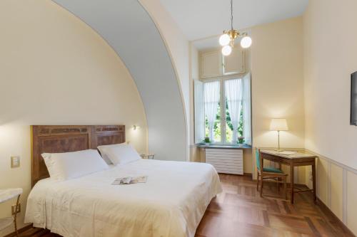 a bedroom with a bed and a desk and a window at Hotel Roma e Rocca Cavour in Turin
