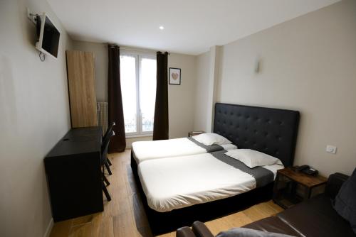 a bedroom with two beds and a desk and a window at LAFAYETTE HOTEL in Paris