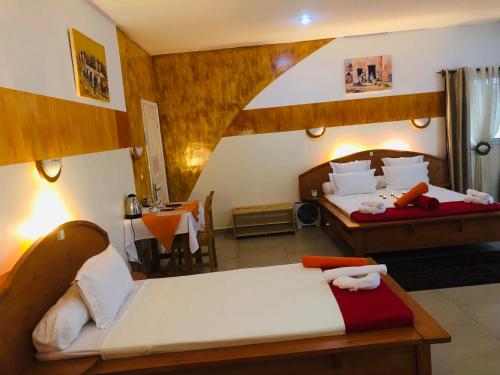a hotel room with two beds and a table with a table at Petite Flower Guest House in Talata-maty