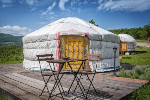 a yurt with a table and chairs on a wooden deck at Società Agricola Cacigolara in Borgo Val di Taro