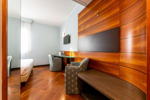 a room with wood paneling and a bed and a desk at Hotel Mirage Sure Hotel Collection by Best Western in Milan