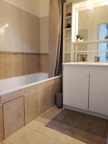une salle de bain avec une baignoire et un lavabo dans l'établissement Résidence Dalimier #hypercentre#, à Corbeil-Essonnes