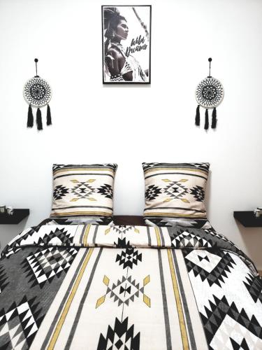 une chambre avec un lit avec une couette noire et blanche dans l'établissement Résidence Dalimier #hypercentre#, à Corbeil-Essonnes