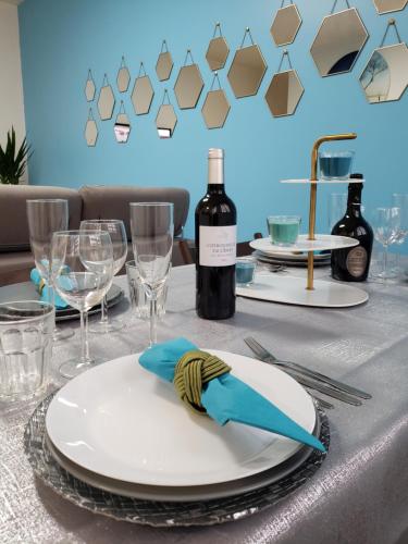 - une table avec une assiette blanche et une bouteille de vin dans l'établissement Résidence Dalimier #hypercentre#, à Corbeil-Essonnes