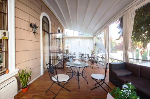 a porch with a couch and chairs and a table at Villa Pirandello in Rome