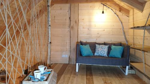 - un canapé dans l'angle d'une chambre dotée de murs en bois dans l'établissement Kabanéo - gîte et sauna- Samois sur Seine - Forêt de Fontainebleau, à Samois-sur-Seine