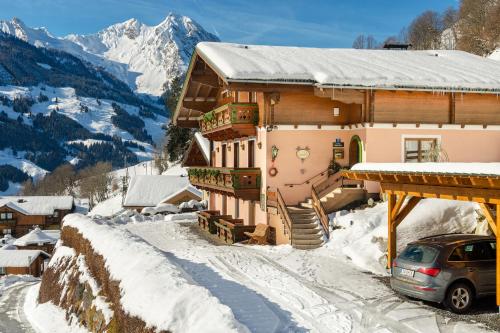 a house with a car parked in the snow at Gästehaus Hagenhofer in Dorfgastein