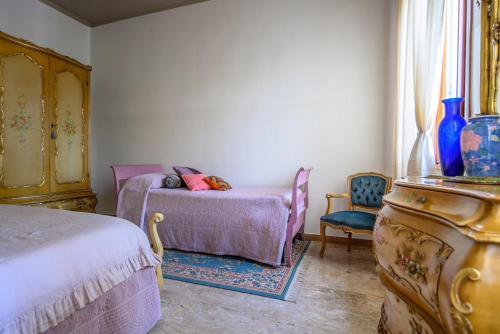 a bedroom with a bed and a chair and a dresser at La Casa di Tina in Favaro Veneto