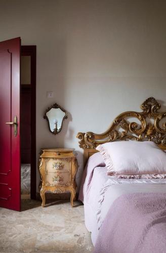 a bedroom with a bed and a table and a mirror at La Casa di Tina in Favaro Veneto