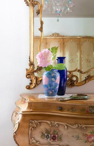 a table with a vase with a pink flower on it at La Casa di Tina in Favaro Veneto