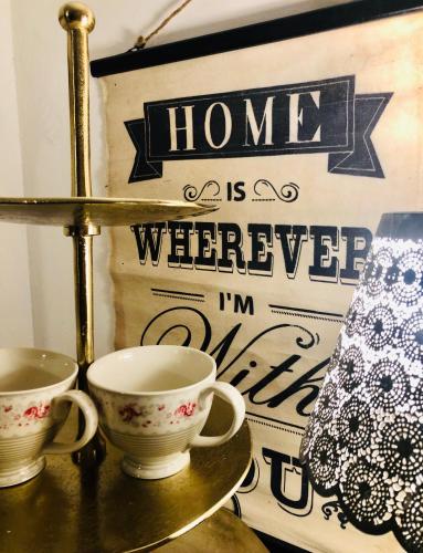 two cups on a gold shelf with a home is whatever im at Gästehaus Weiherhof in Alpbach
