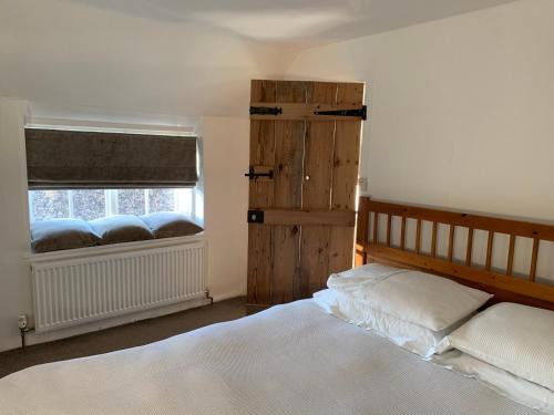 sypialnia z łóżkiem i oknem w obiekcie Bell Cottage w mieście Mildenhall