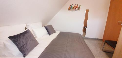a bedroom with a bed with white sheets and pillows at Ferienwohnungen Saida Wohnung 2 in Norden
