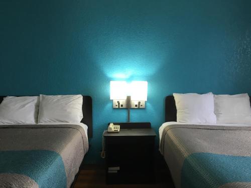 Zimmer mit 2 Betten und einer Lampe an der Wand in der Unterkunft FairBridge Inn Express Melrose Park in Melrose Park