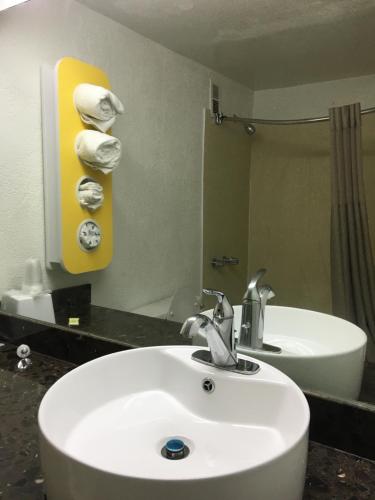 a bathroom with a sink and a mirror at FairBridge Inn Express Melrose Park in Melrose Park