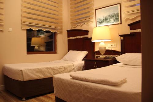 Habitación de hotel con 2 camas y ventana en Adrasan La Casita Hotel, en Adrasan