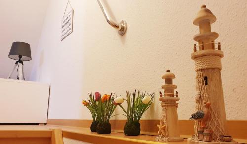 a table with some flowers in vases on it at Ferienwohnungen Saida Wohnung 2 in Norden