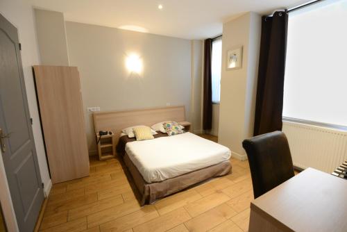 Habitación pequeña con cama y mesa en LAFAYETTE HOTEL en París