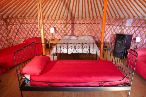 a bed in a yurt with a red blanket at Società Agricola Cacigolara in Borgo Val di Taro