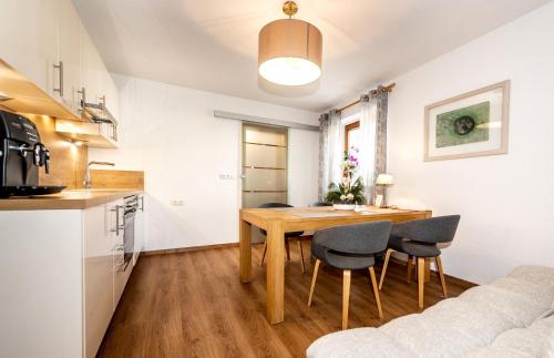 a kitchen and dining room with a wooden table and chairs at Alpen Appartements Marlene in Ehrwald