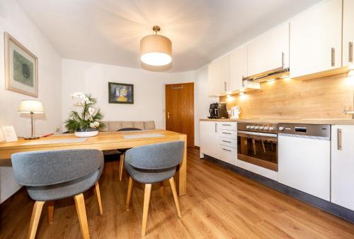 a kitchen with a wooden table and chairs at Alpen Appartements Marlene in Ehrwald