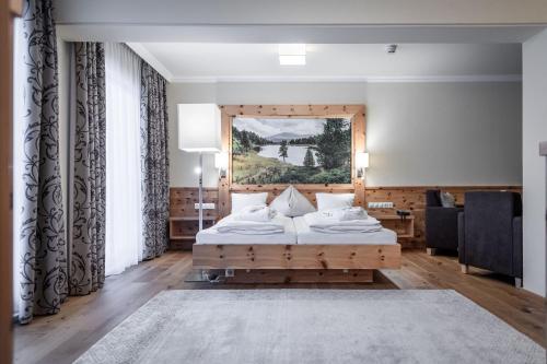 ein Schlafzimmer mit einem Bett und einem großen Fenster in der Unterkunft Hotel Kornock in Turracher Hohe