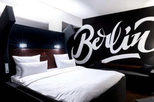 
a hotel room with a bed and a lamp at The Weinmeister Berlin-Mitte - Adults Only in Berlin
