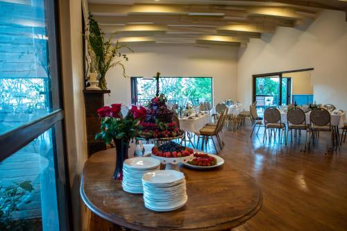 een eetkamer met een tafel met borden en bloemen bij Far Hills Country Hotel in George