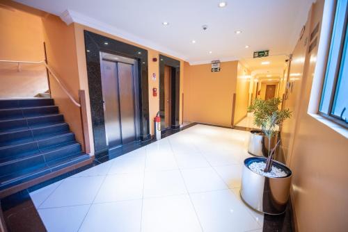a hallway of an office building with stairs and potted plants at Hotel Alles Blau in Pelotas